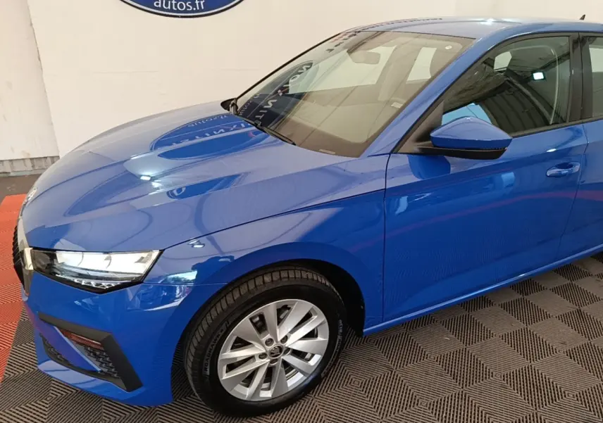 Vue 3/4 avant droit d'une Skoda Scala bleu 2024 avec jantes alliage et rétroviseurs noirs.