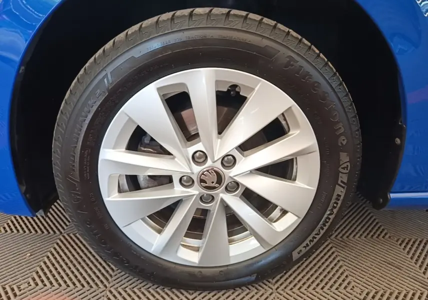 Gros plan sur la roue avant droite d'une Skoda Scala bleu 2024 avec jante alliage argentée et pneu Firestone.