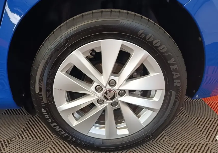 Gros plan sur la roue avant gauche d’une Skoda Scala bleue avec jante alliage argent et pneu Goodyear.