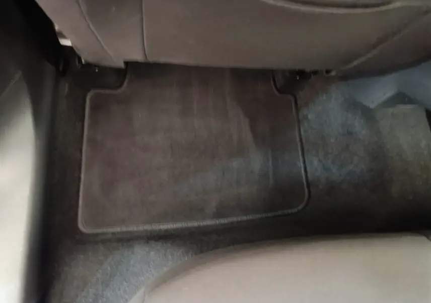 Vue du sol arrière côté droit de la Skoda Scala 2024, tapis de sol noir et siège tissu gris visible.