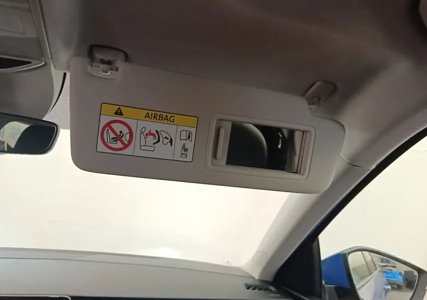 Détail du pare-soleil côté conducteur avec miroir intégré et avertissement airbag dans un Skoda Scala bleu 2024.