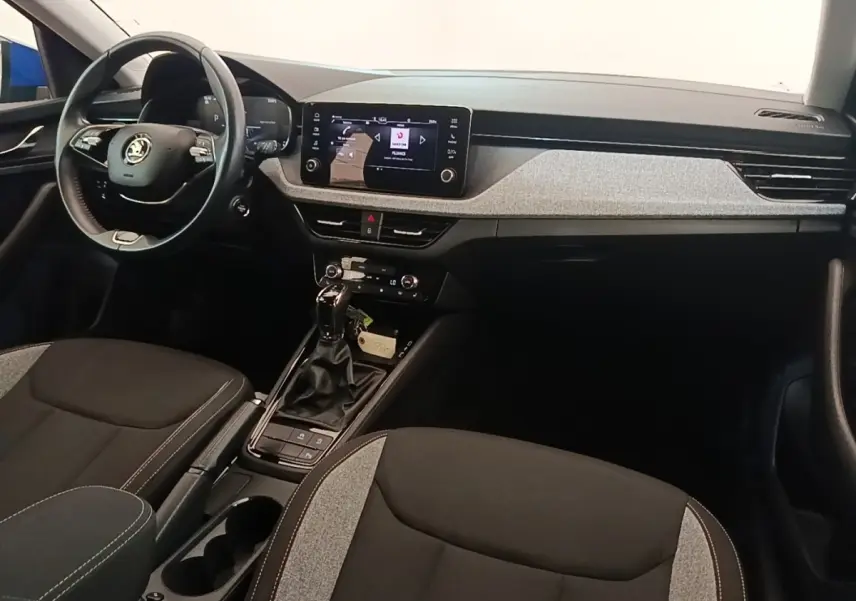 Vue intérieure avant droite de la Skoda Scala 2024, tableau de bord avec écran tactile et volant cuir alu multifonctions.