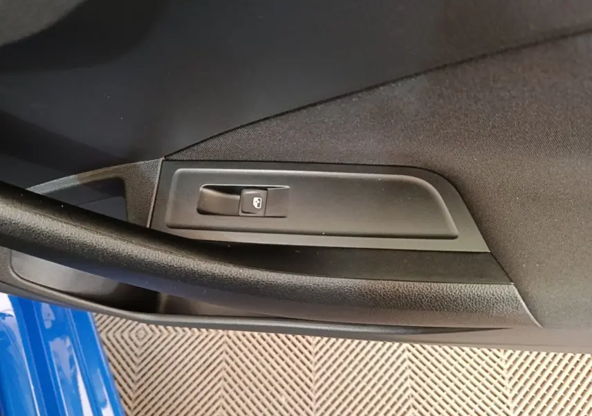 Détail de la commande de verrouillage de porte côté gauche d’une Skoda Scala bleu 2024.