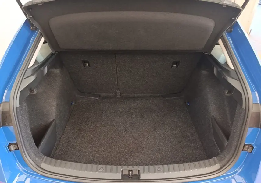 Coffre ouvert vu de l'arrière d'une Skoda Scala 1.5 TSI bleu 2024, montrant l'espace de chargement vide.