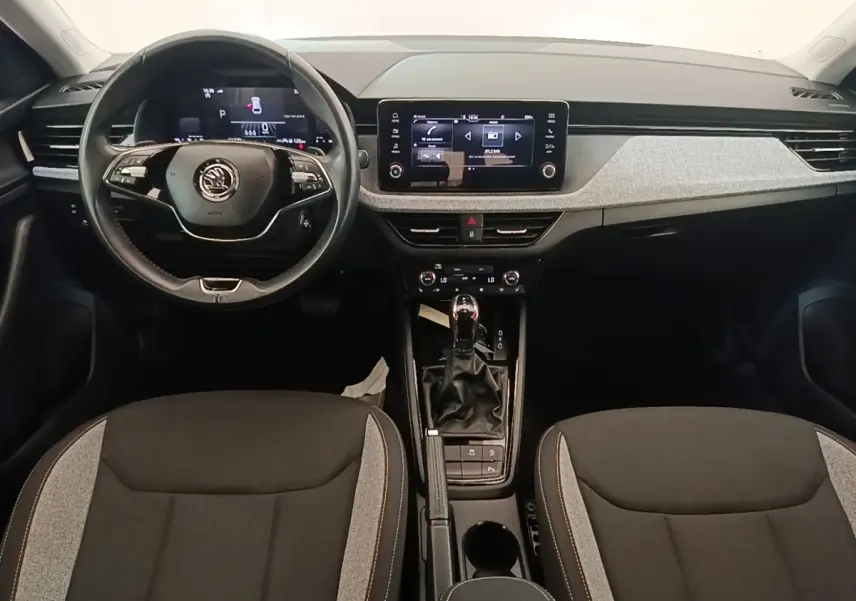 Vue intérieure avant du Skoda Scala 2024, tableau de bord moderne avec écran tactile central et volant multifonctions cuir.