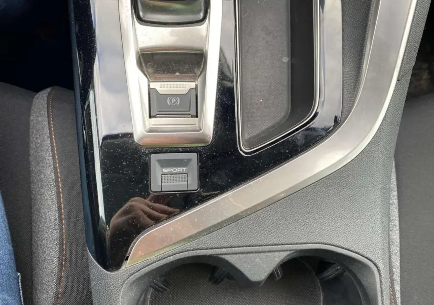 Gros plan sur la console centrale noire du Peugeot 3008 2019 avec bouton sport et frein à main électrique.