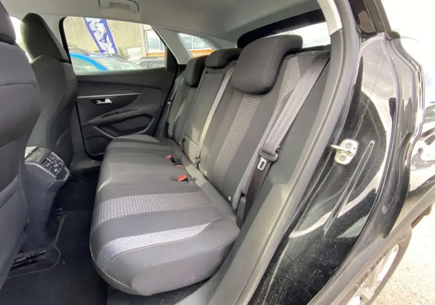 Vue intérieure du siège arrière côté droit d'un Peugeot 3008 noir de 2019 avec sellerie tissu et ceintures grises.