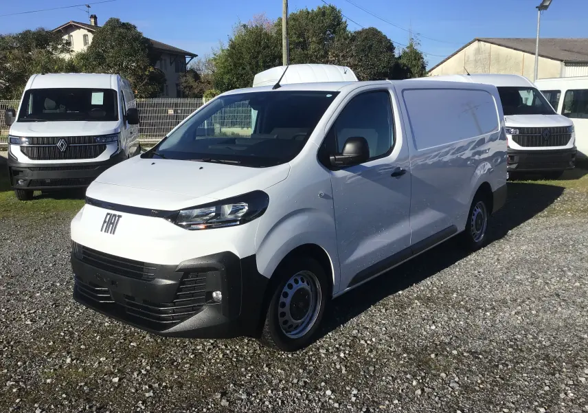 Fourgon FIAT Scudo XL blanc en 3/4 avant droit, avec garde au sol rehaussée et plaque de protection tôlée visible.