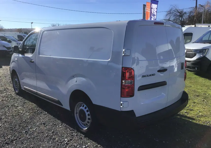 Fiat Scudo Fourgon blanc vu en 3/4 arrière droit, fourgon utilitaire avec hayon arrière et jantes acier simples.