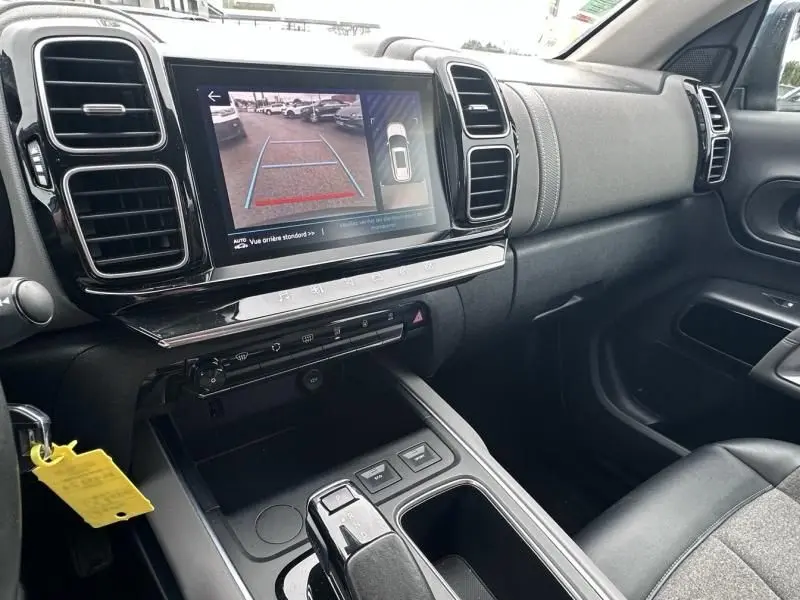 Vue intérieure côté passager du tableau de bord et console centrale du Citroën C5 Aircross Bleu Tijuca avec écran tactile affichant la caméra de recul.