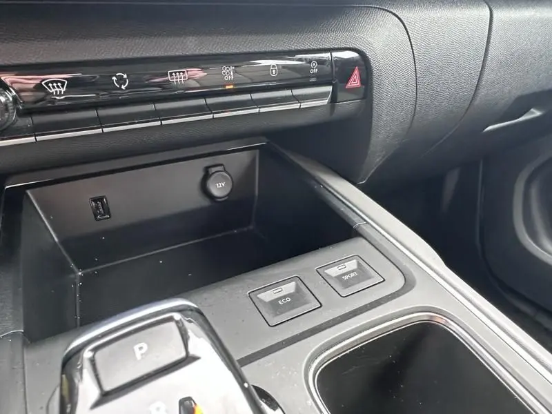 Gros plan sur la console centrale intérieure du Citroën C5 Aircross bleu Tijuca, montrant les boutons Eco et Sport et la prise 12V.