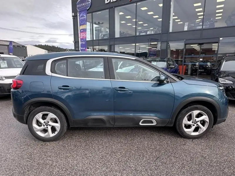 Vue de profil côté droit du Citroën C5 Aircross Bleu Tijuca 2021 avec protections noires et jantes argentées.