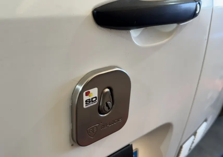 Gros plan sur la serrure de sécurité RB-Locks sur la porte blanche côté gauche d’un Citroën Berlingo 2020.