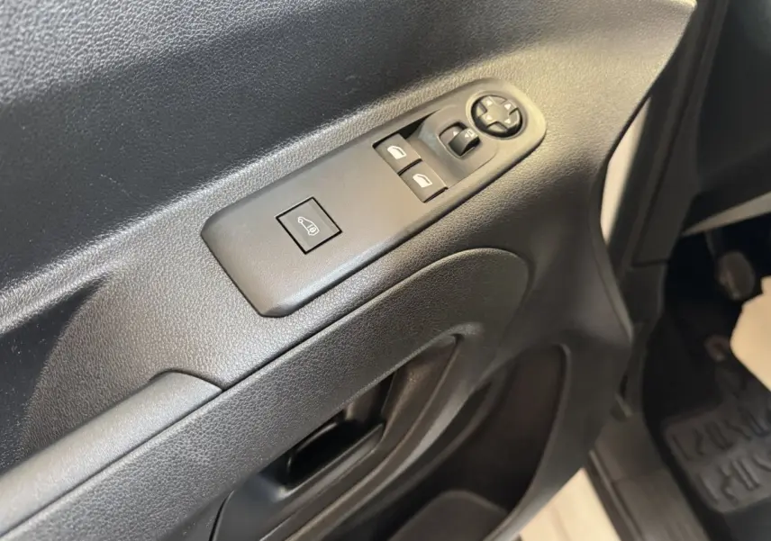 Détail de la porte côté conducteur du Citroën Berlingo blanc, montrant les commandes électriques des vitres et rétroviseurs.
