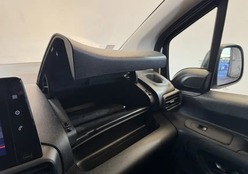 Vue intérieure côté passager du coffre à gants ouvert du Citroën Berlingo blanc, montrant le tableau de bord et la portière.