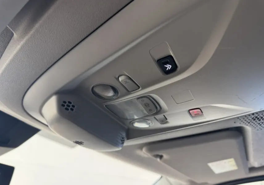 Plafonnier intérieur gris clair du Citroën Berlingo 2020 avec commandes d’éclairage et bouton d’alerte rouge visible.