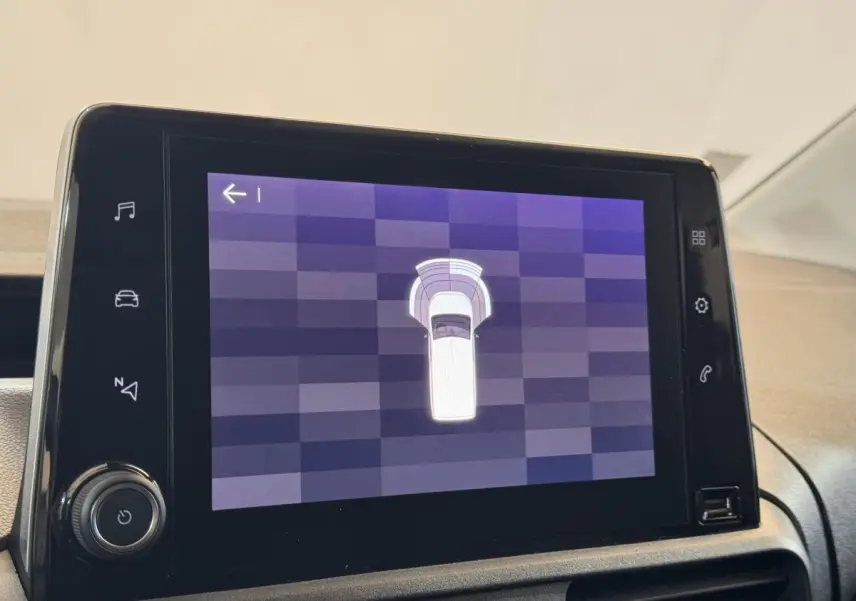 Écran tactile central affichant l'aide au stationnement du Citroën Berlingo blanc, vue intérieure du tableau de bord.