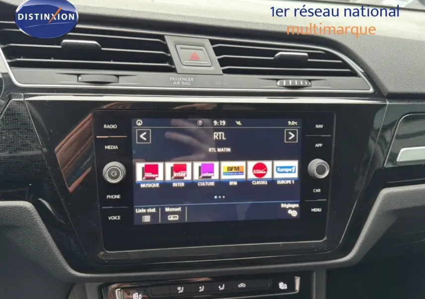 Vue rapprochée de l’écran tactile central noir du tableau de bord d’un Volkswagen Touran blanc de 2018.