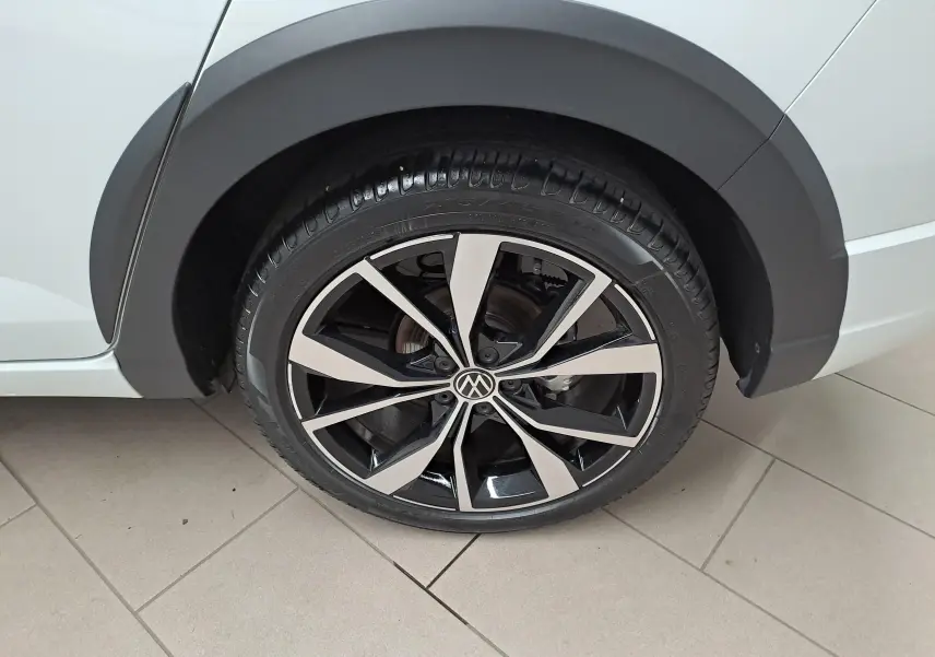 Gros plan sur la jante alliage 18 pouces bicolore du côté arrière droit du Volkswagen Taigo blanc toit noir.