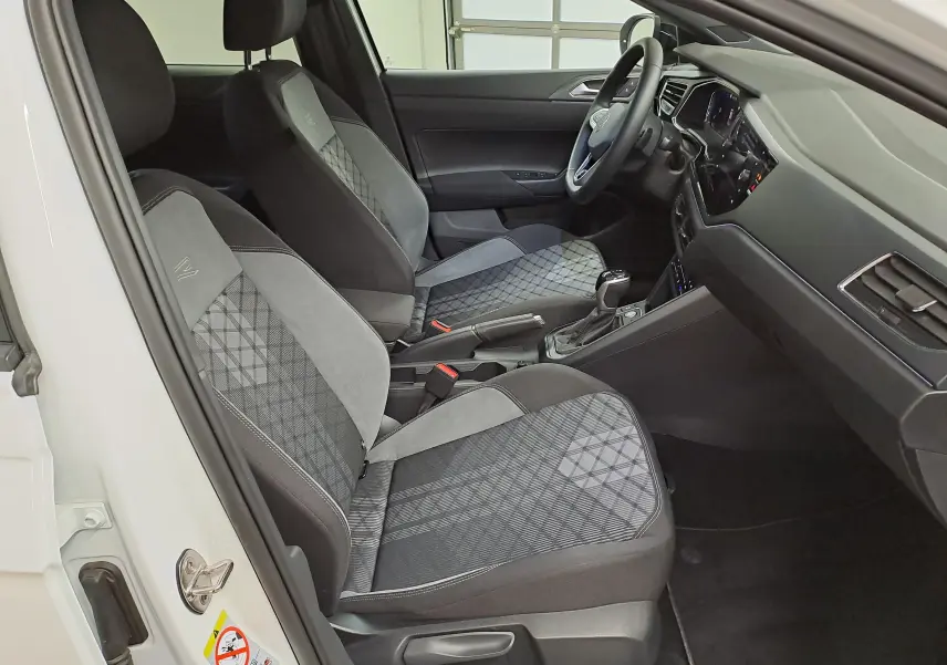 Vue intérieure côté gauche du Volkswagen Taigo 1.5 TSI 150 DSG7 R-Line Edition avec sièges tissu gris à motifs géométriques.