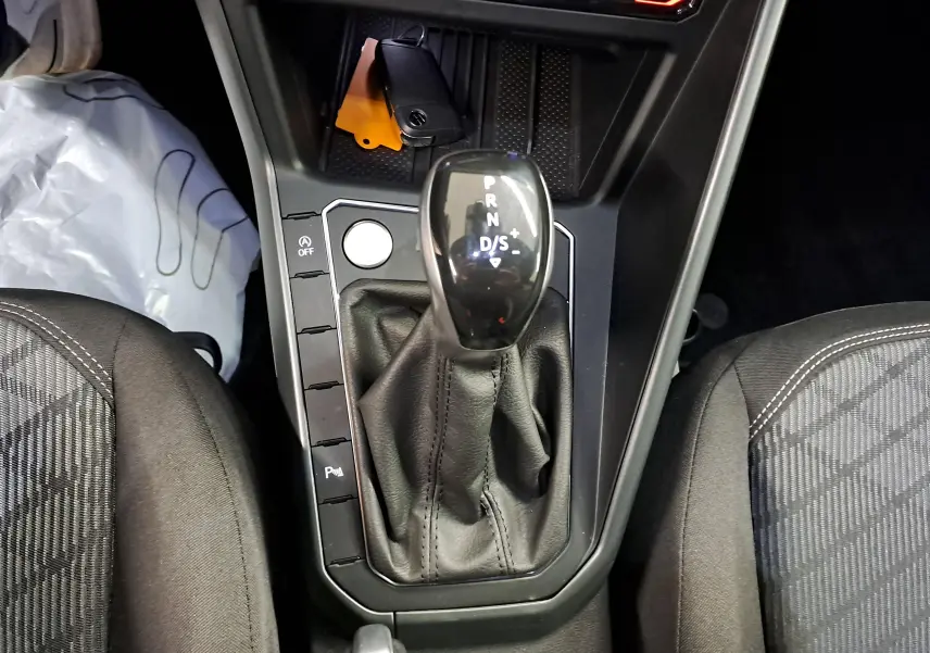 Vue rapprochée de la console centrale du Volkswagen Taigo 1.5 TSI 150 DSG7 R-Line avec levier de vitesse automatique.