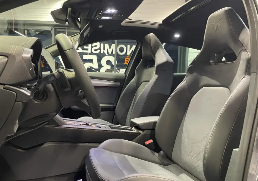 Vue intérieure côté gauche du CUPRA Formentor gris Graphene, sièges baquets suédine noire avec surpiqûres cuivrées et logo Cupra.