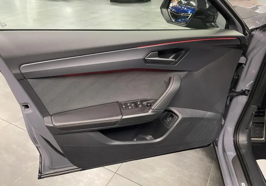 Contre-porte côté conducteur gris Graphene avec surpiqûres cuivrées et bandeau lumineux rouge du CUPRA Formentor 2026.