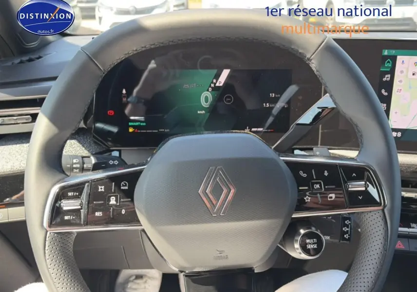 Vue rapprochée du volant noir de la Renault Clio VI 1.2 TCe 115 Techno EDC avec commandes intégrées et tableau de bord numérique.