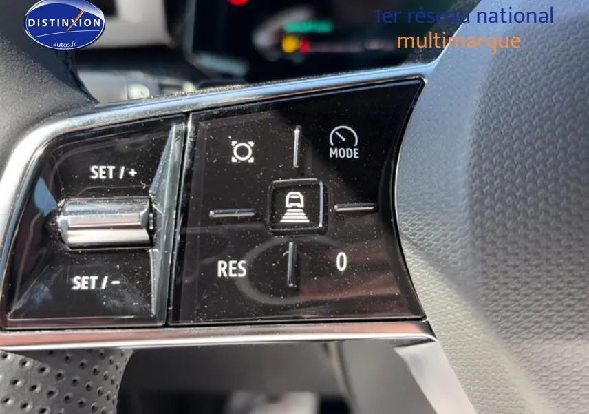 Gros plan sur les commandes du volant noir de la Renault Clio VI 1.2 TCe 115 Techno EDC, avec boutons de régulateur et mode de conduite.