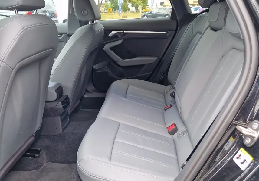 Vue intérieure côté droit des sièges arrière gris clair d'une Audi A3 Sportback noire, avec détails modernes et espace généreux.