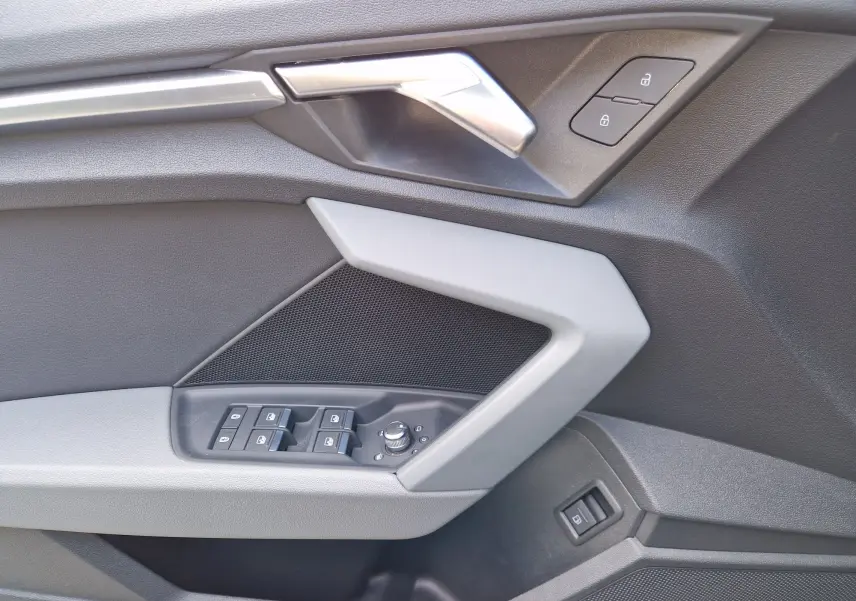 Détail de la porte côté conducteur de l'Audi A3 Sportback 40 TFSI-e noire, avec commandes des vitres et verrouillage.