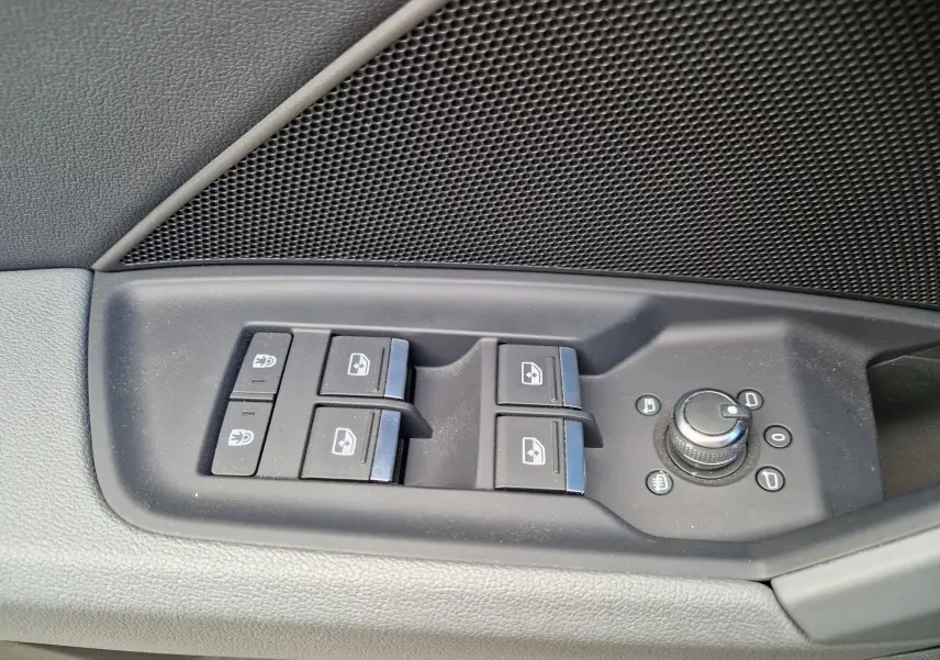 Gros plan sur les commandes de lève-vitres et réglage des rétroviseurs côté gauche d’une Audi A3 Sportback noire.