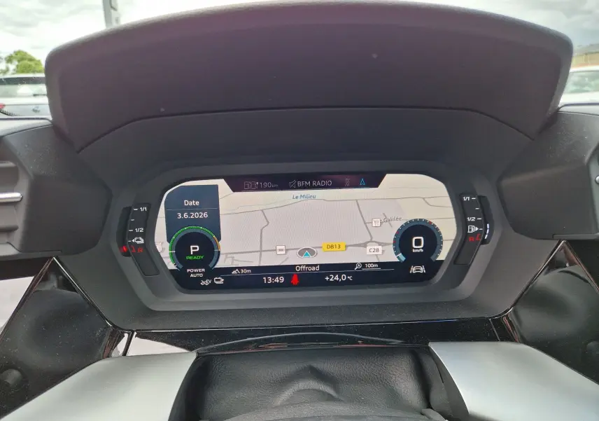 Vue rapprochée du tableau de bord numérique de l'Audi A3 Sportback noir, affichant la navigation et les informations de conduite.