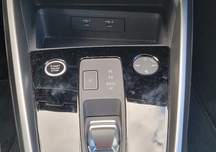 Vue rapprochée de la console centrale noire de l’Audi A3 Sportback 40 TFSI-e avec levier de vitesse automatique et boutons de contrôle.
