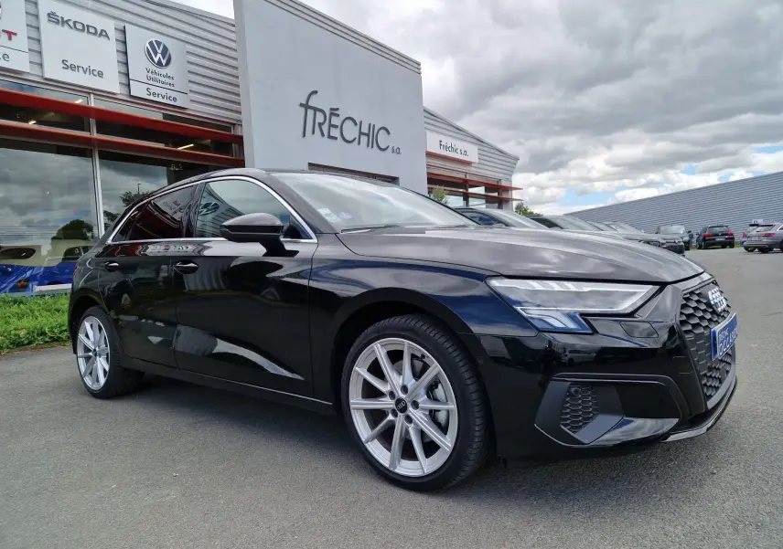 Audi A3 Sportback noir vue 3/4 avant droit, mettant en valeur ses jantes argentées et ses phares LED distinctifs.