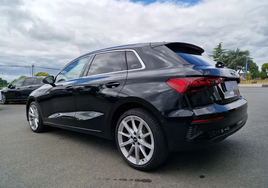 Audi A3 Sportback noir vue 3/4 arrière droit, mettant en valeur ses feux LED et jantes alliage argentées.