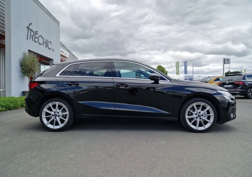 Audi A3 Sportback noir vue de profil côté gauche, avec jantes alliage et lignes épurées visibles.