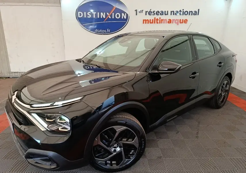 Vue 3/4 avant droite d'une Citroën C4 X noire 2023 avec phares LED et jantes alliage distinctives.