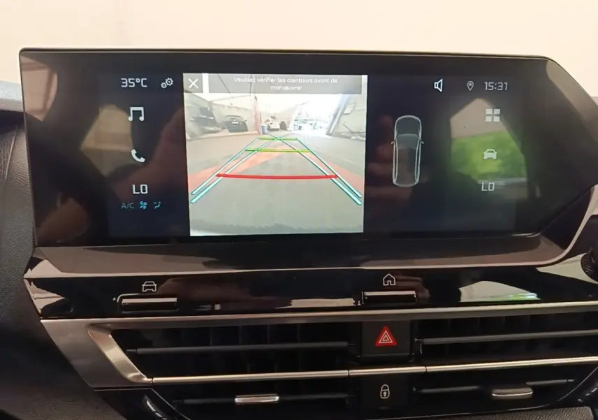 Écran tactile central du tableau de bord du Citroën C4 X noir, affichant la caméra de recul et les aides au stationnement.