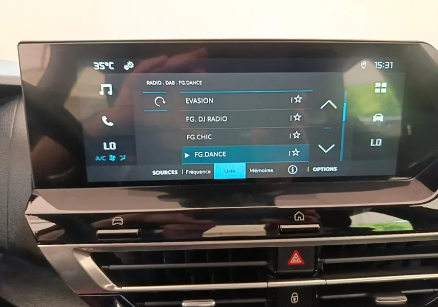 Vue rapprochée de l’écran tactile central du tableau de bord de la Citroën C4 X 2023 affichant les options radio et climatisation.
