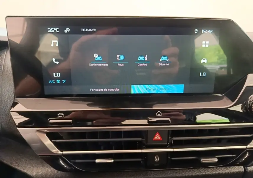 Écran tactile central du tableau de bord de la Citroën C4 X 2023 avec commandes climatisation et fonctions de conduite affichées.