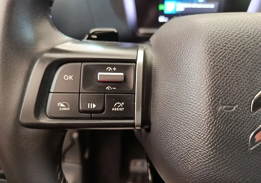 Gros plan sur les commandes multifonctions à gauche du volant cuir noir du Citroën C4 X 2023.