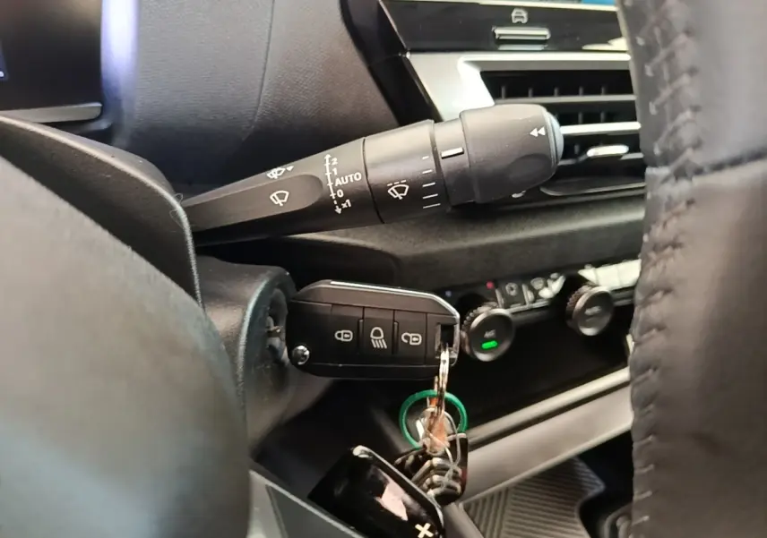 Gros plan sur la clé insérée dans le contacteur côté gauche du tableau de bord noir de la Citroën C4 X 2023.