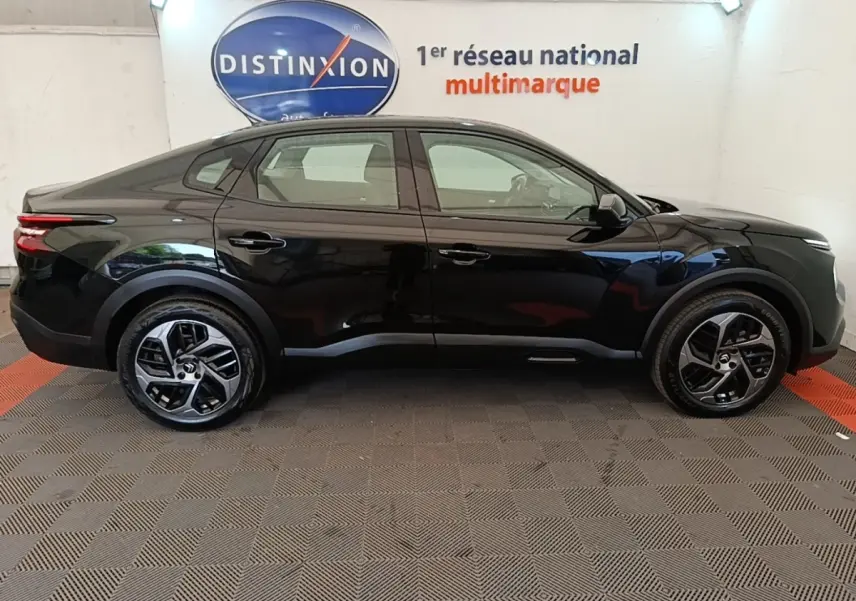 Profil côté gauche d'une Citroën C4 X noire 2023, finition Feel Pack, avec jantes alliage et feux arrière LED distinctifs.