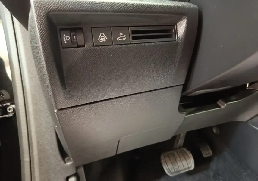 Détail intérieur côté gauche du tableau de bord noir de la Citroën C4 X avec commandes d’éclairage et assistance.