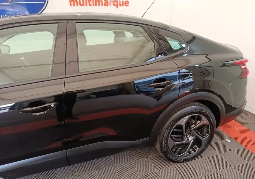 Vue côté droit arrière d'une Citroën C4 X noire 2023 avec jantes noires et feux arrière LED distinctifs.