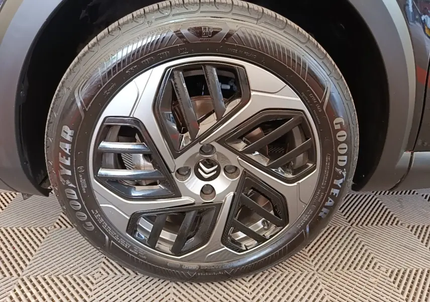 Gros plan sur la roue avant gauche noire avec jante alliage bicolore et pneu Goodyear d'une Citroën C4 X 2023.