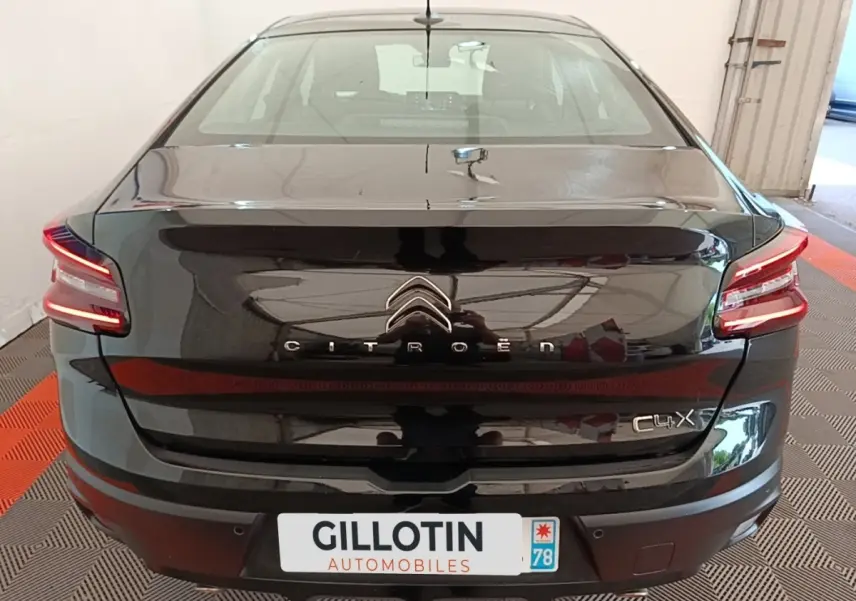 Vue arrière d'une Citroën C4 X noire 2023 avec feux LED et spoiler de coffre visible en intérieur.