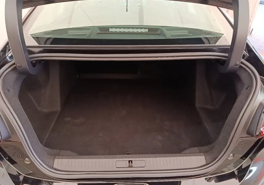 Coffre ouvert de la Citroën C4 X noire, vue arrière montrant l’espace de chargement vide et le seuil de coffre.