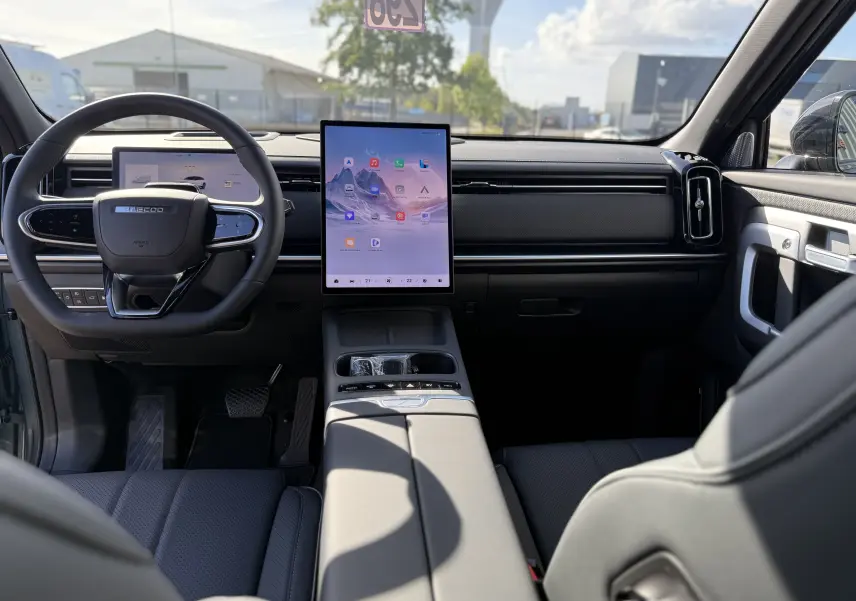 Vue intérieure avant du JAECOO J7 PHEV 279 CH en argent, avec grand écran tactile vertical et volant multifonction.